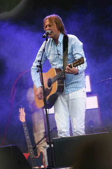 Artist med akustisk gitar på scene