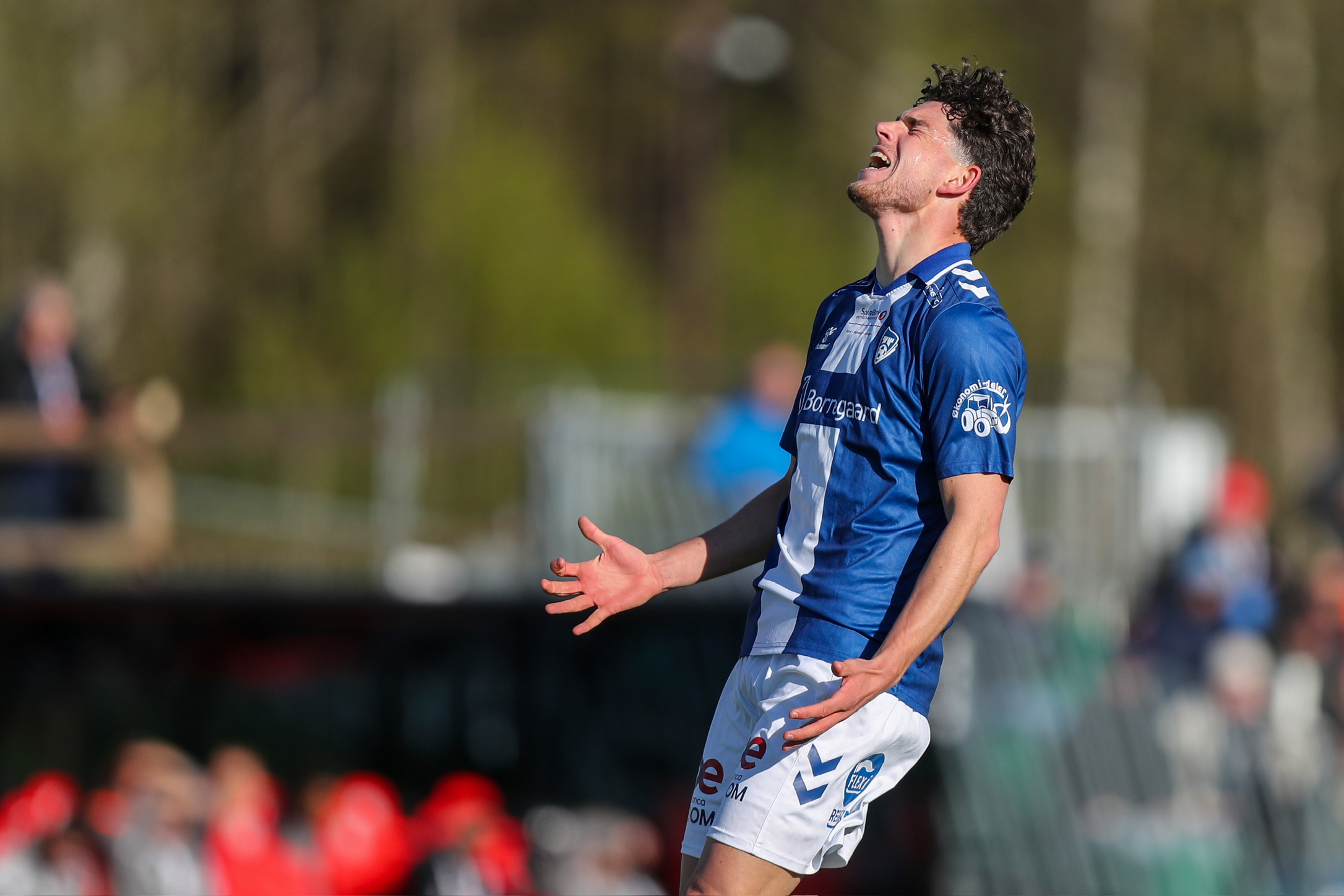 Fotballspiller reagerer med armene ut