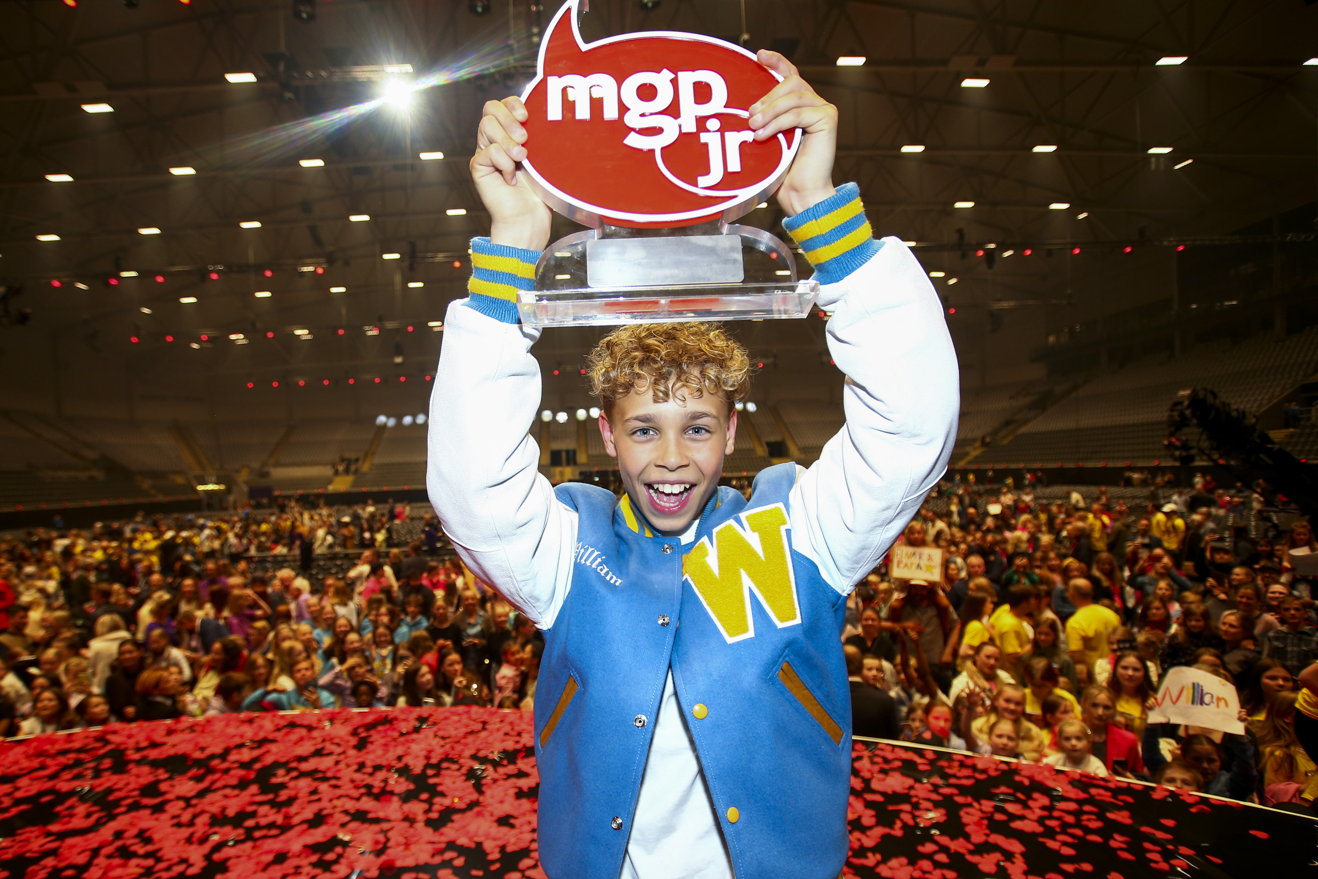 Vinner med pokal foran publikum